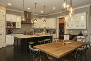 The wellequipped kitchen includes a Wolf range, Sub-Zero refrigerator, oversized walk-in pantry and sleek gray subway tile backsplash from Walker Zanger.