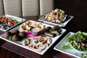 Babylon Café’s Middle Eastern appetizers called “mezza” are beautiful and abundant: tahini-dressed eggplant badenjan (left); a platter with heaped with falafel, hummus, “dulma” and baba ghanoush; fattoush salad (rear) and tabbouleh (right).