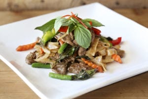 Bangkok Station's Drunken Man noodles with beef sizzles with crushed fresh chiles and assorted peppers.