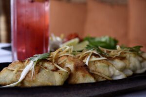 Pan-crisped dumplings (sui cao chien) filled with minced chicken, scallions and ginger are enhanced with umami-rich black vinegar sauce.