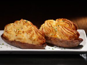 Loaded potatoes are twice-baked with creme fraiche and Vermont cheddar and studded with salty bacon.
