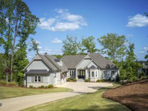 Situated at the bottom of a descending driveway, the home is set back from the road, but right up against the lake.