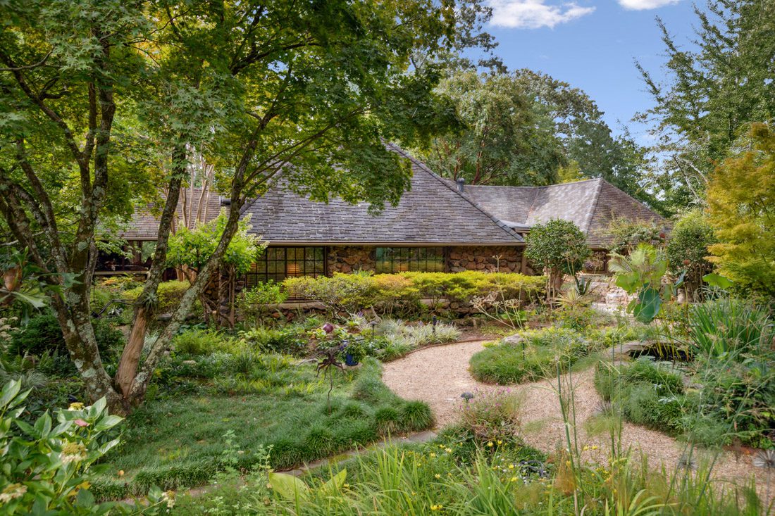 An English-style fieldstone house in Brookhaven has a lush yard that nods to Asian influences. Courtesy of HOME Georgia/Cathy Boston