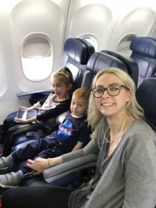 Beauty writer Emily Foley braving an airplane ride with her two littles in 2018.