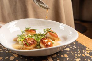 Perfectly seared scallops swim in decadent brown butter.