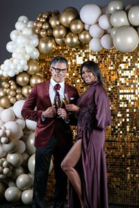 Wardrobe: On Brenda: Lapointe lightweight satin caftan top with feathers ($990), Lapointe lightweight satin asymmetric maxi skirt ($850), Deepa Gurnani earrings ($100), available at Tootsies. On Pedro: Brown three-piece suit ($599), available at Connaisseur Paris.