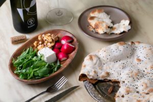 A sabzi plate of nibbles and warm, fresh taftoun bread are complimentary accompaniments.
