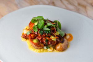 Smoky octopus is served with corn, potatoes, sorrel and a duo of bright sauces.