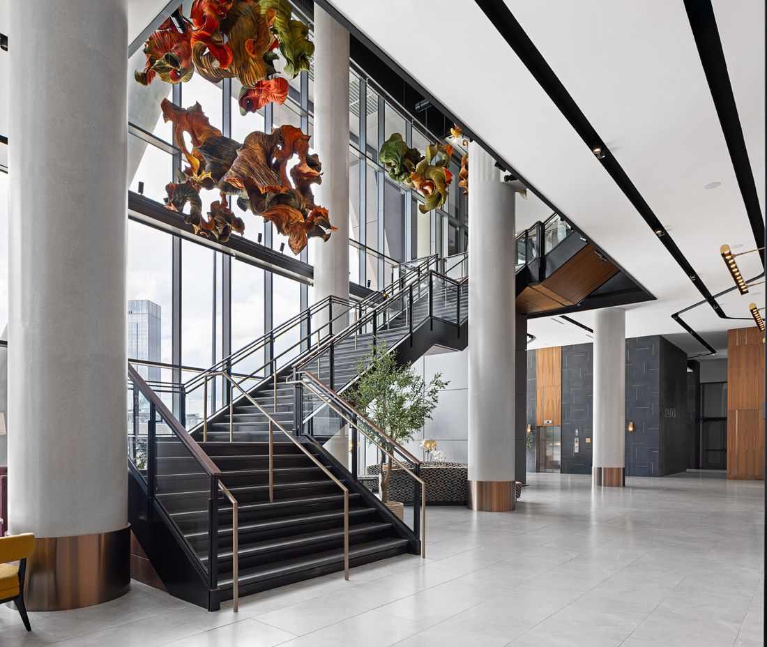 The lobby features eye-catching sculptures suspended above an open stairwell.