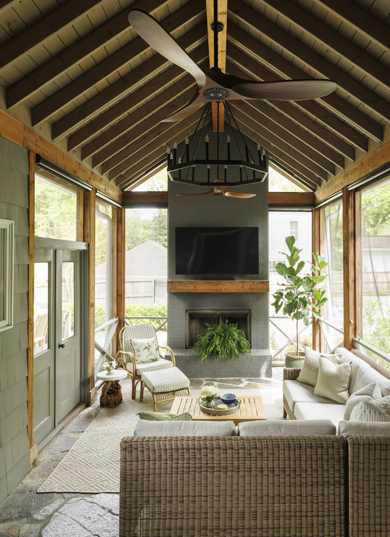 Visual Comfort Maverick fans keep the screened-in porch cool, while the fireplace comes in handy when the weather turns cool.