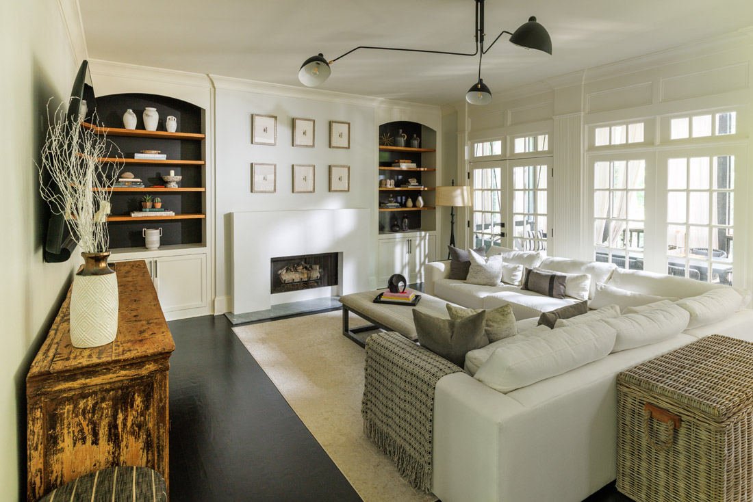 The television is intentionally not placed above the fireplace, so the room remains about connection and conversation.